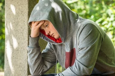 Nedstämd ungdom sitter i en park
