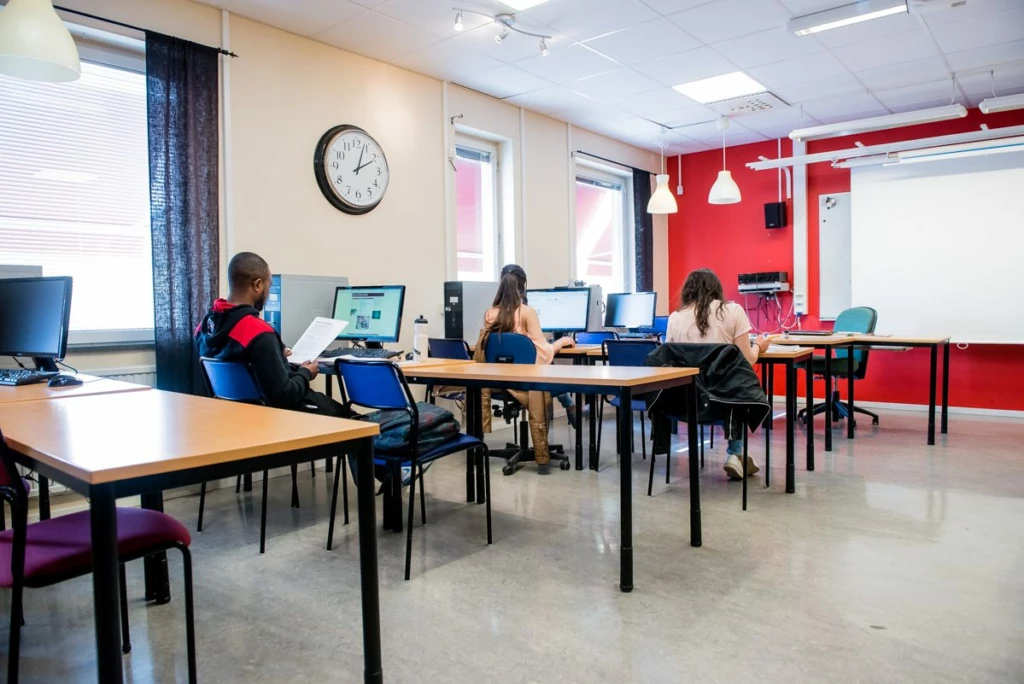 ett klassrum med skolbänkar och elever