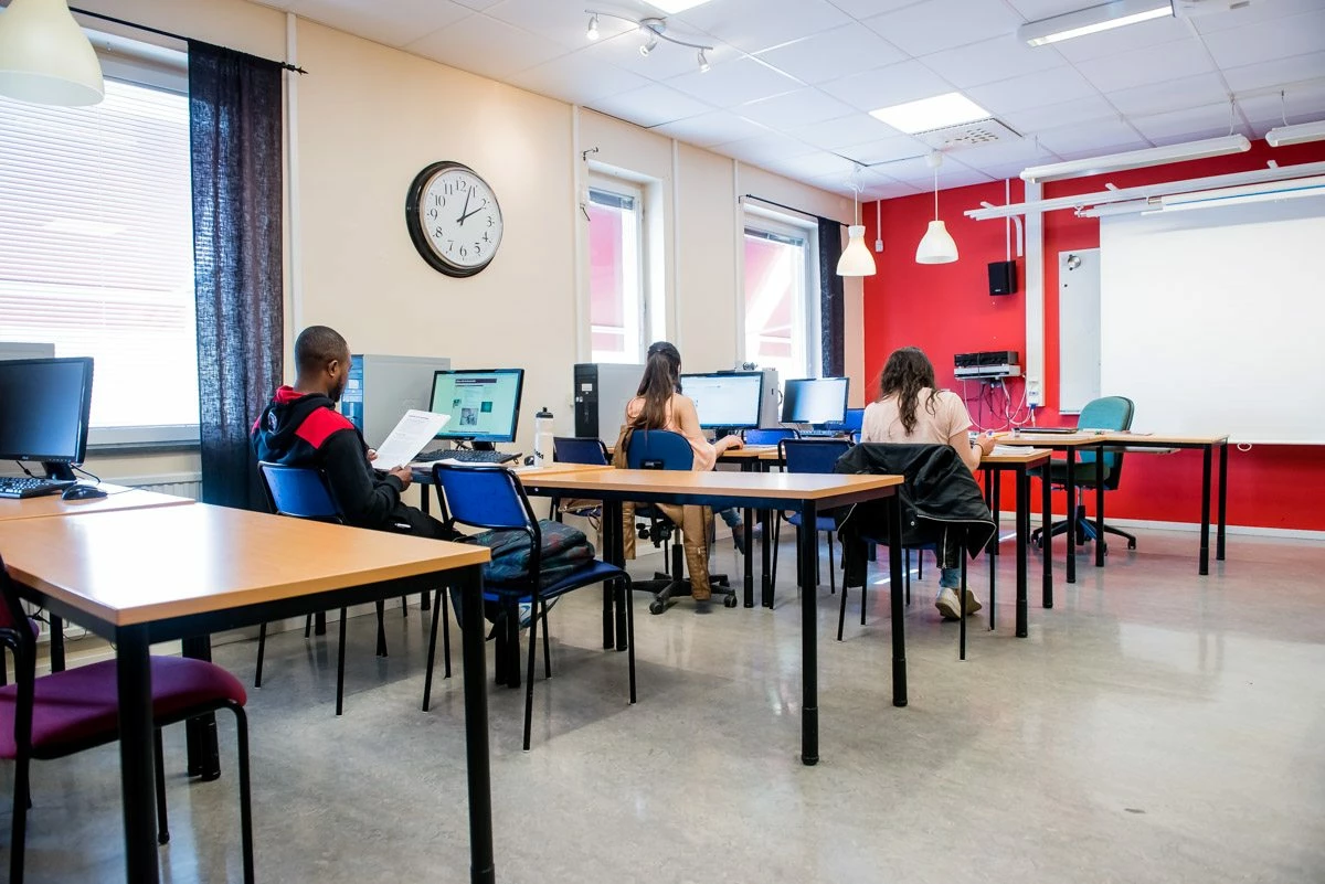 ett klassrum med skolbänkar och elever