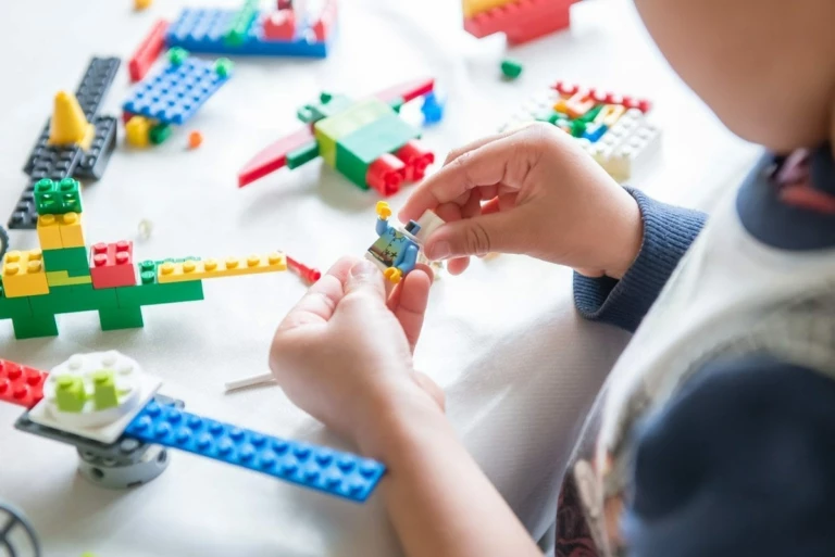 händer som bygger med lego.