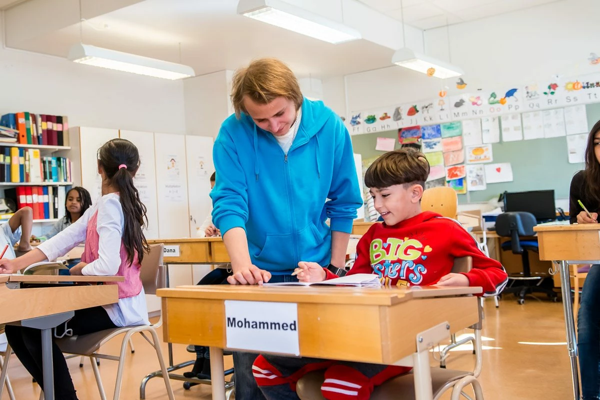 en lärare hjälper en elev i ett klassrum