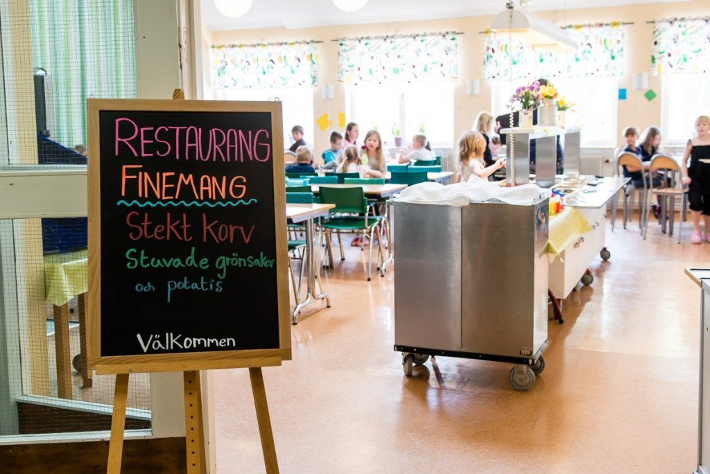 Bild på ingången till matsalen på Stora Skedvi skolan, där elever sitter och äter.
