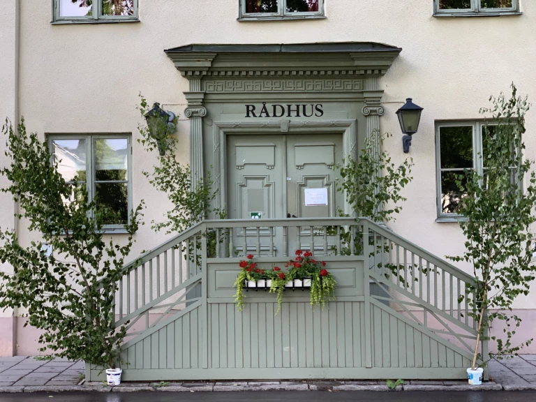 En gammal blågrön dörr vid en trappa.