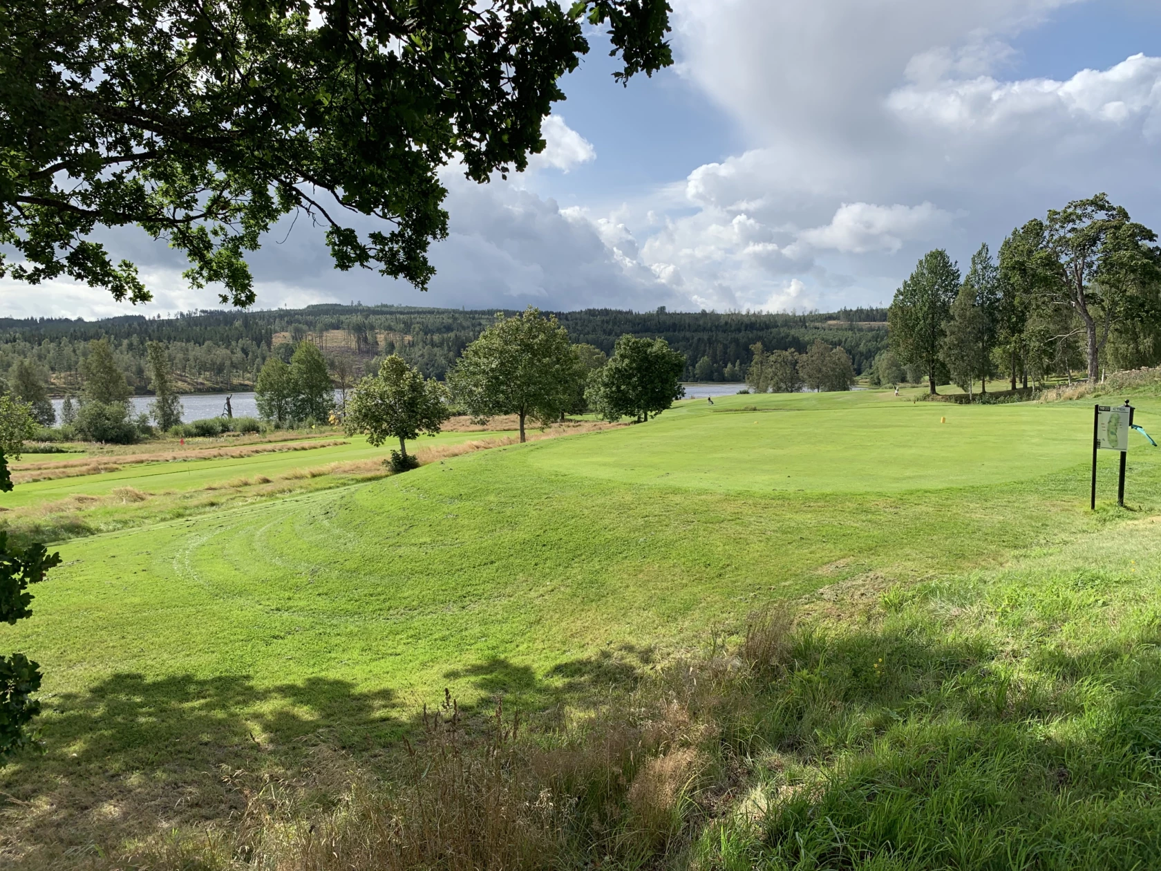 En miljö bild över Säters golfbana med blå himmel och grönområden
