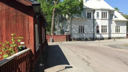En gata med ett rött plank och äldre hus.