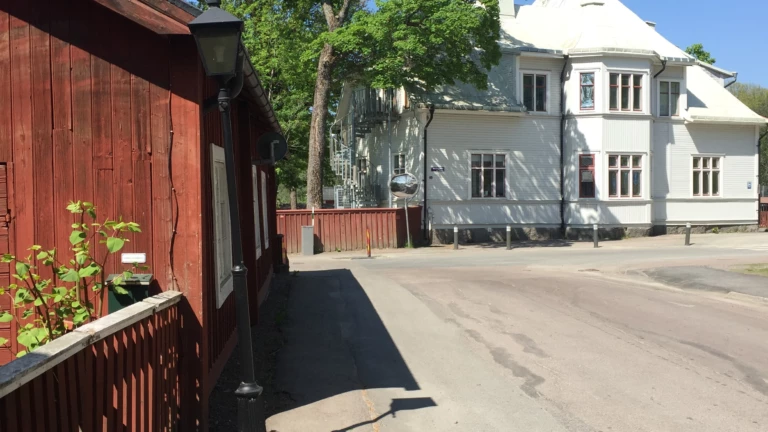 En gata med ett rött plank och äldre hus.