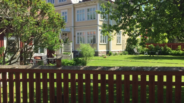 Detalj av staket och byggnad.