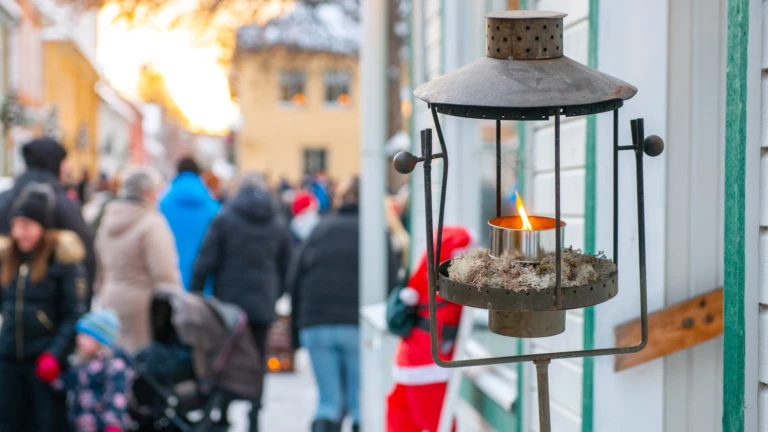 Gammaldags lykta på fasad med julmarknaden i Säter i bakgrunden