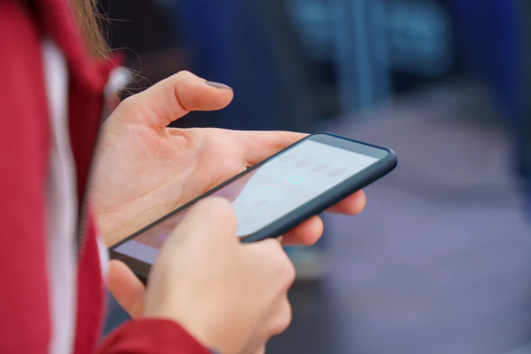 Person läser sms på mobiltelefon