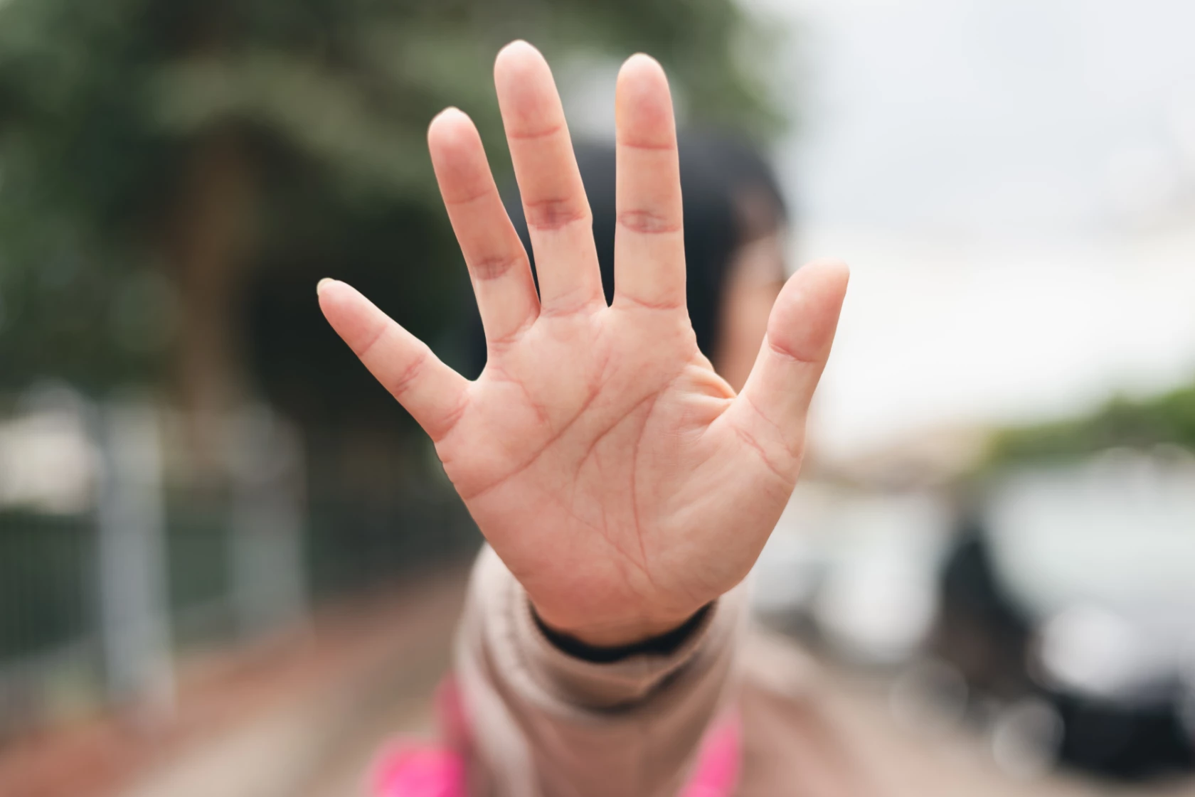 Kvinna visar stopptecken med sin hand.