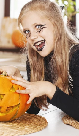 En flicka som är målad i ansiktet med halloween-tema