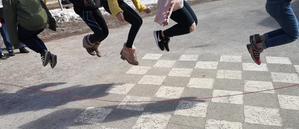 Barn som hoppar hopprep på skolgården.