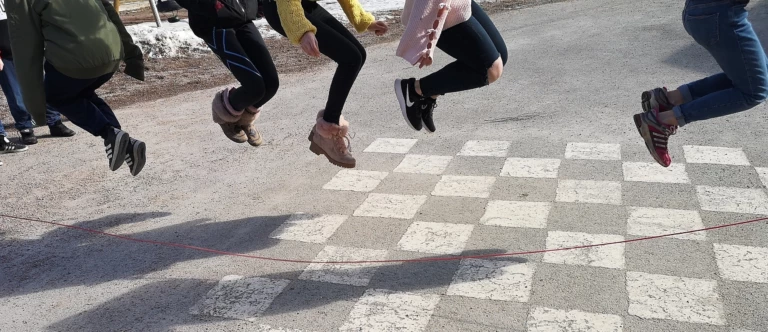 Barn som hoppar hopprep på skolgården.