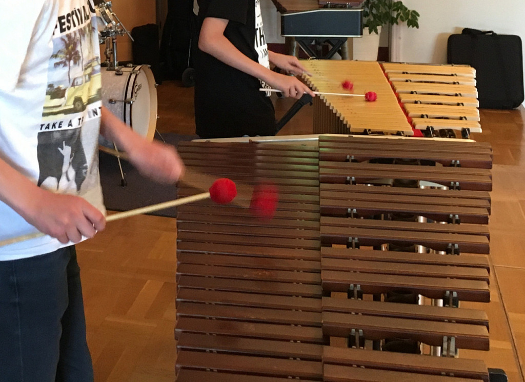 Närbild på när elev spelar på en marimba med klubbor.