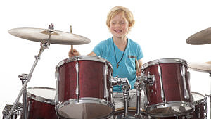 En pojke som spelar trummor.
