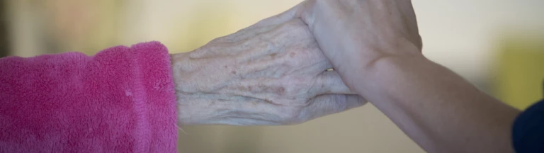 En ung och en äldre hand som håller i varandra