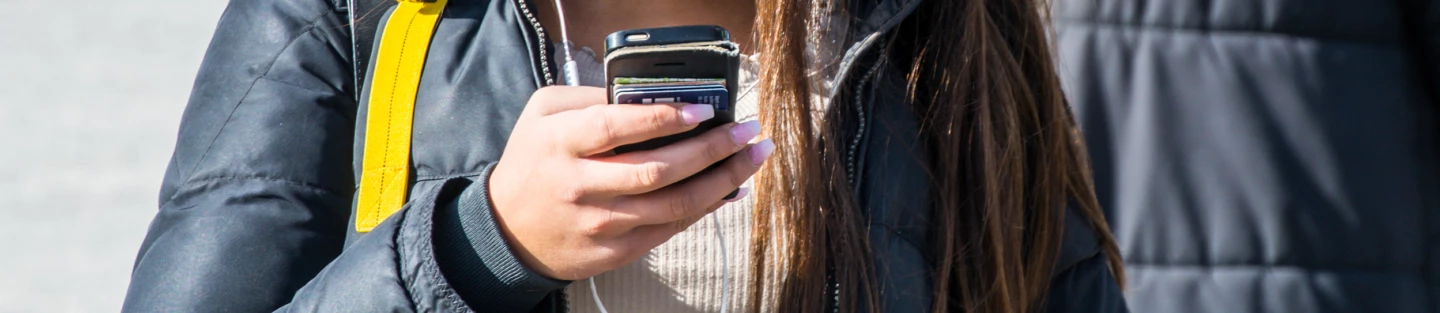 Kvinna pratar i mobiltelefon med hörlurar