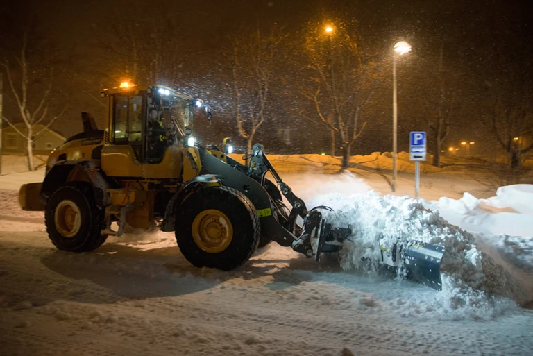 En traktor som plogar snö på en väg