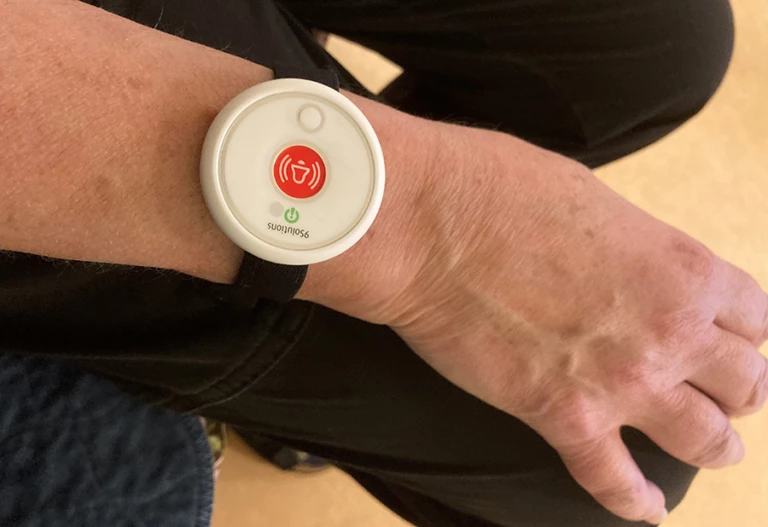 Ett trygghetslarm i form av ett armband som sitter på en handled