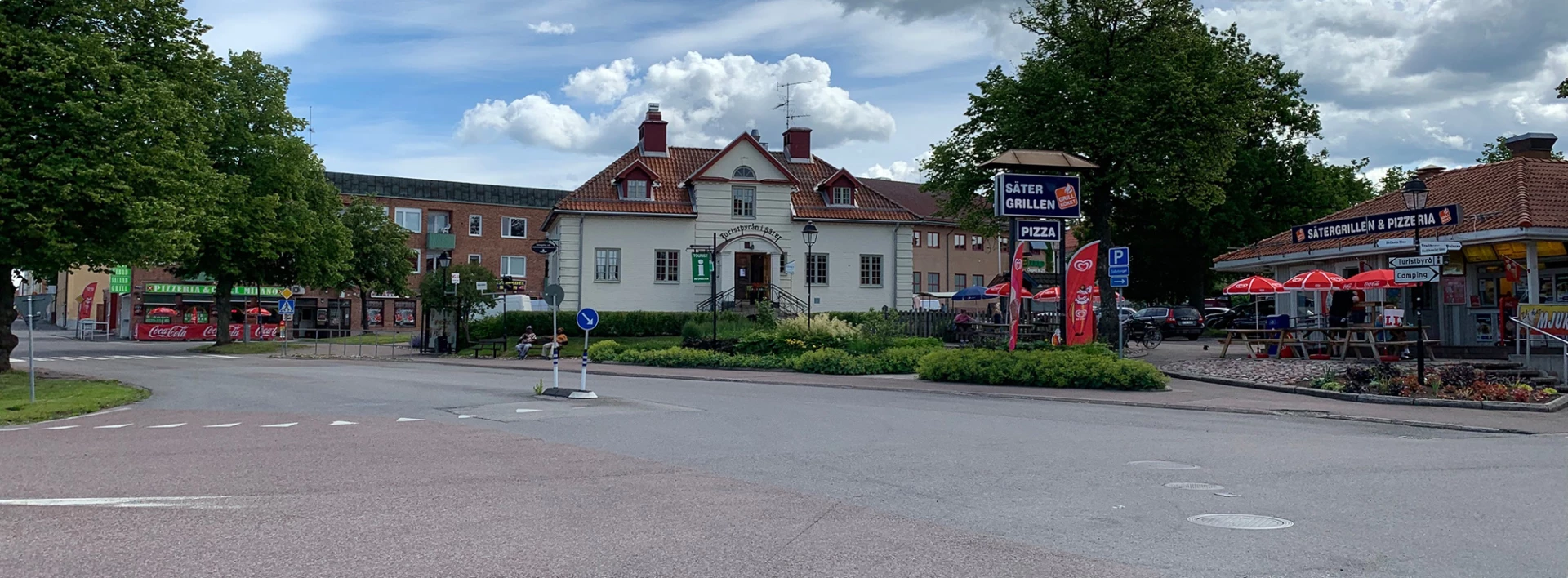 Vy över gatuområde med ett gult stort tegelhus