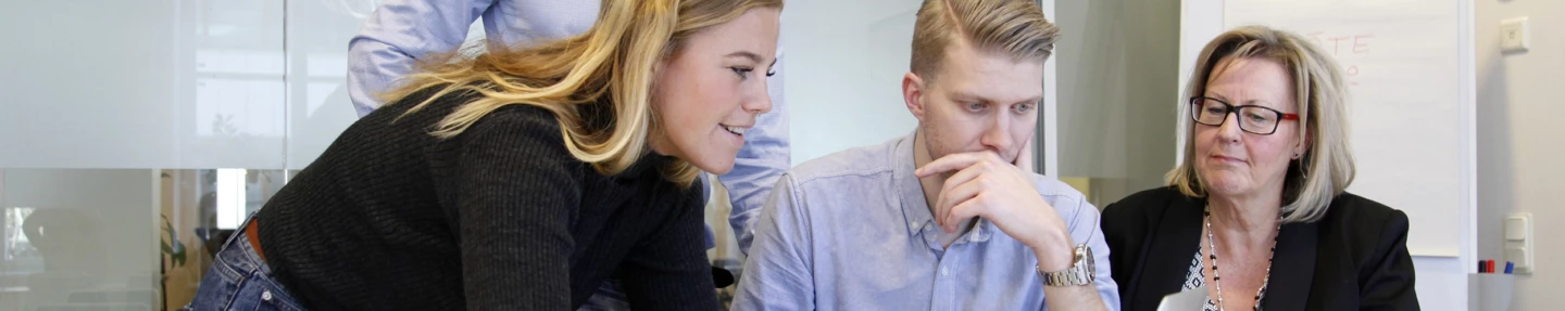 Några människor sitter vid ett bord och diskuterar