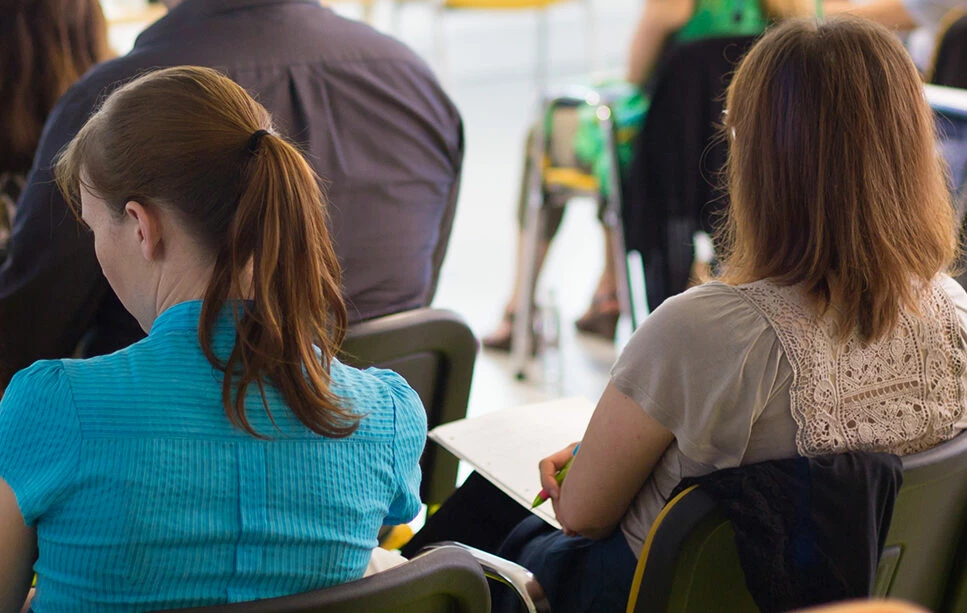 En grupp människor sitter på stolar i ett möte