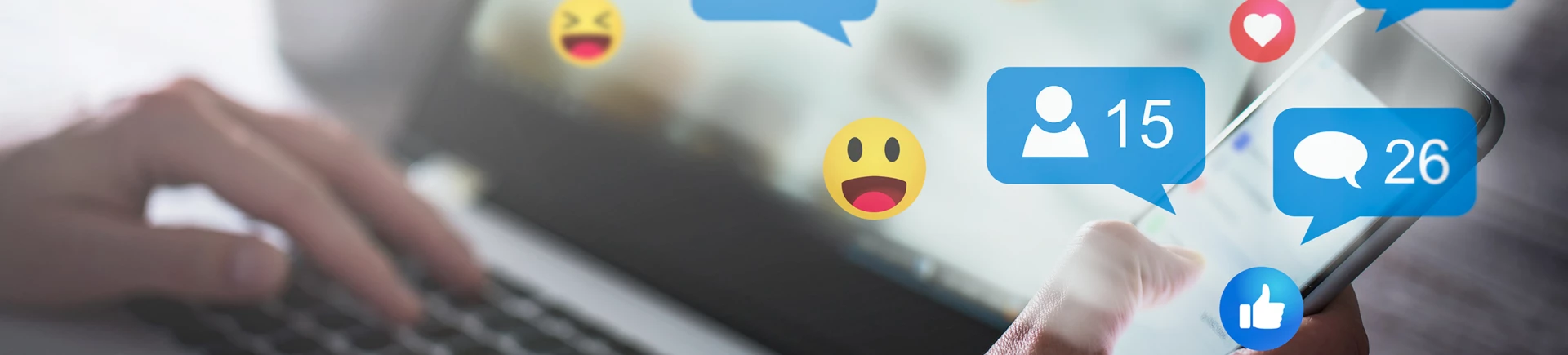 En hand som håller i en mobiltelefon framför en dator