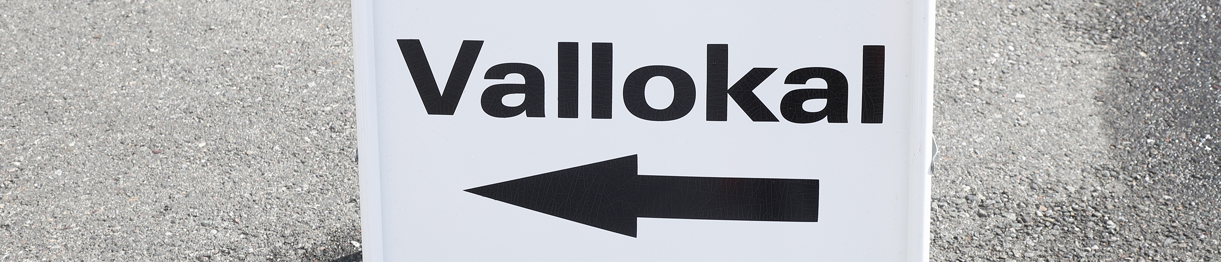 Gatupratare med ordet vallokal och en pil som visar riktningen till lokal där allmänna val hålls.