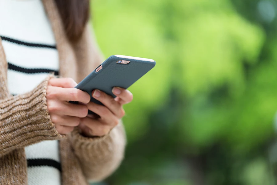 Kvinna tittar i sin mobiltelefon