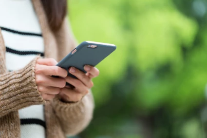 Kvinna tittar i sin mobiltelefon