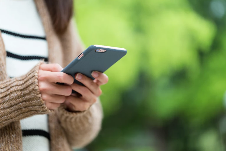 Kvinna tittar i sin mobiltelefon