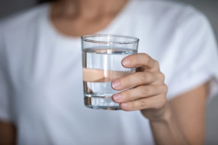 Kvinna håller i ett dricksglas med vatten