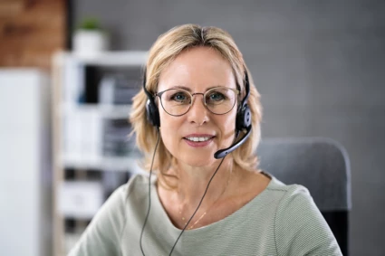 Kvinna med headset som svarar i telefon