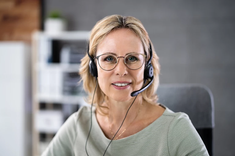 Kvinna med headset som svarar i telefon