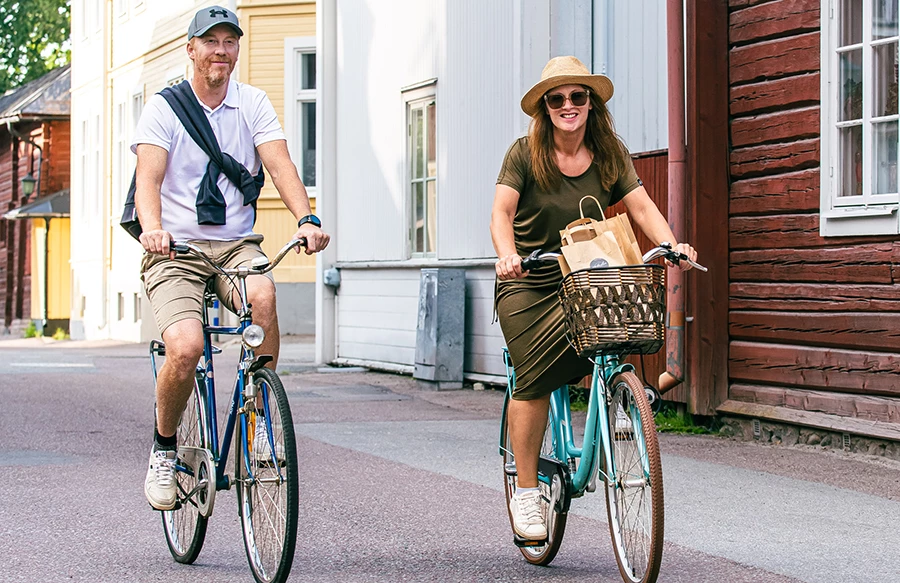 En man och en kvinna som cyklar i en gammal stad