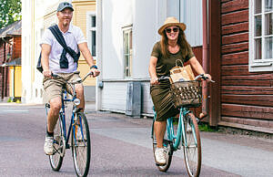 En man och en kvinna som cyklar i en gammal stad