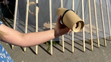 Ett barn som har tillverkat en kikare av kartong