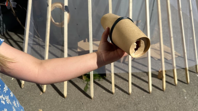 Ett barn som har tillverkat en kikare av kartong