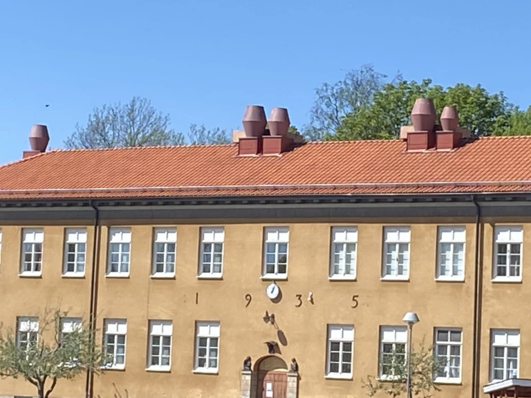 Gul byggnad av sten med många fönster.