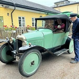 Historiskt klädda herrar vid en gammal bil i säters innerstad