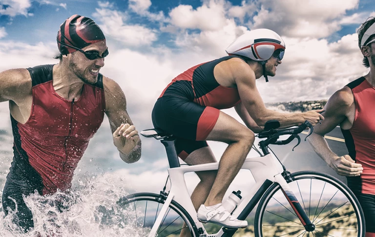 Thriathlon, en person springer, cyklar och simmar