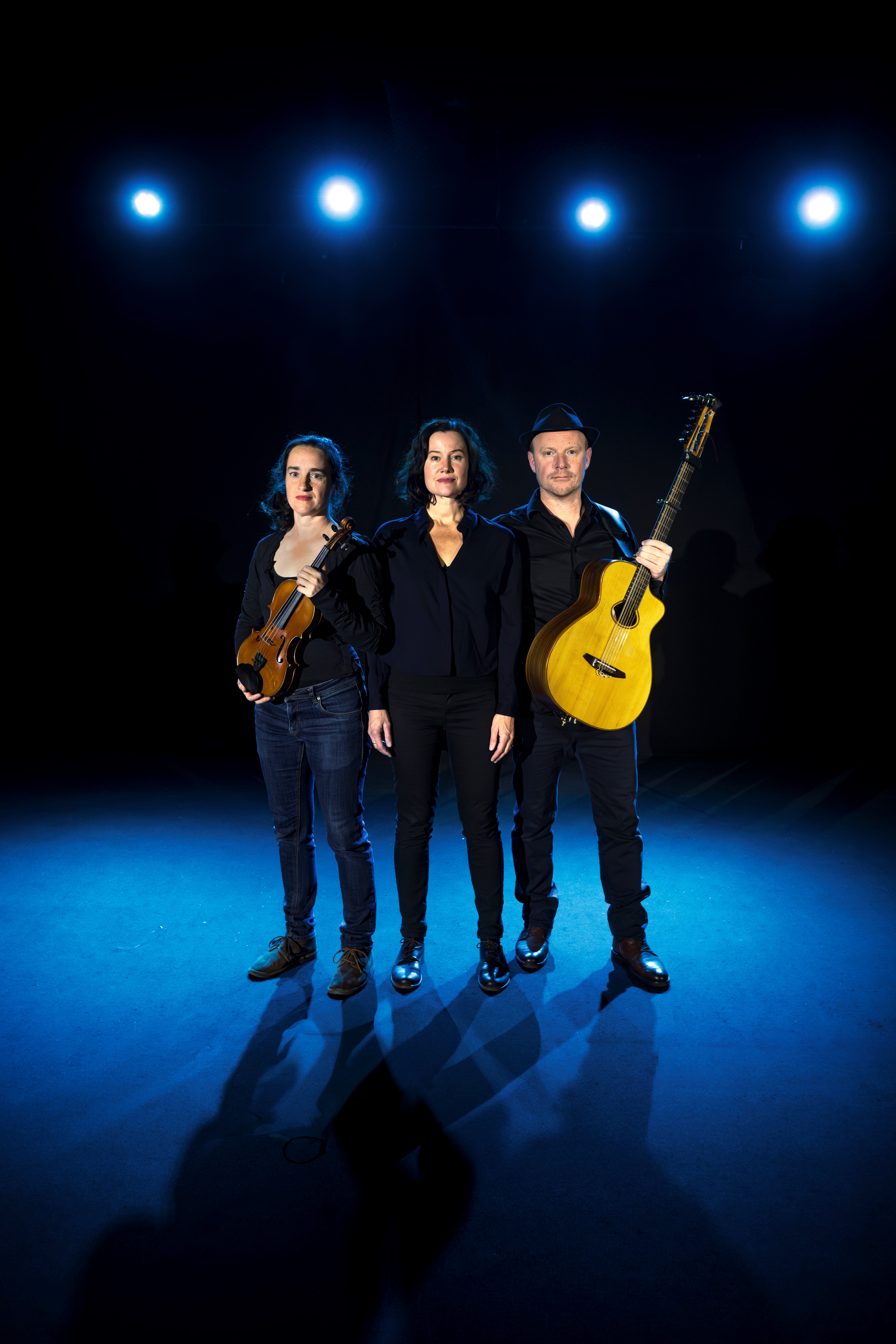 Foto föreställande gruppen Malin Foxdal Trio. De står på scenen med sina musikinstrument