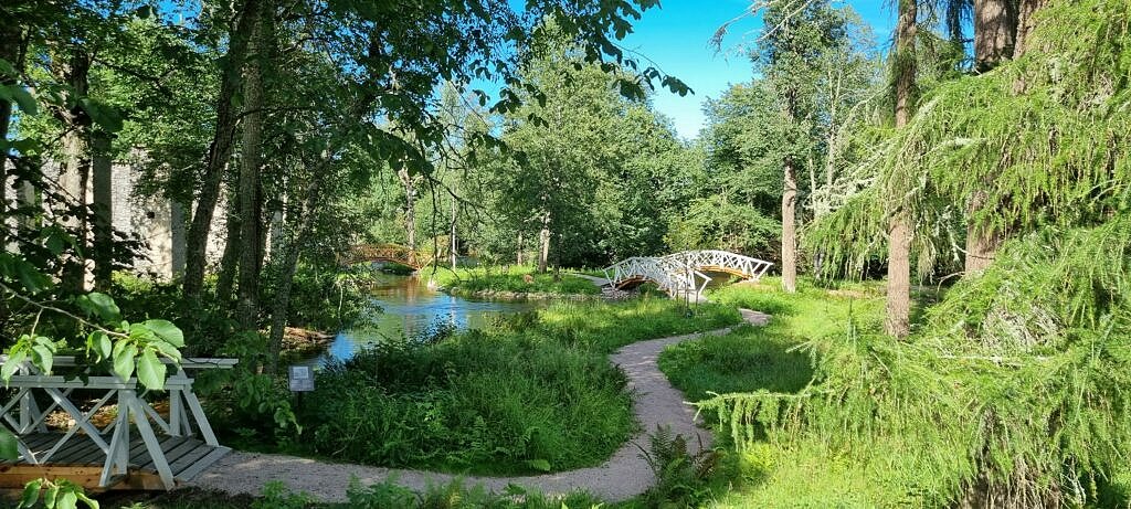 Foto på den Engelsa parken i Grängshammar, säters kommun. Grönskande träd, små träbroar över porlande bäckar