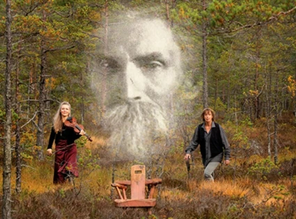 En fantasifull bild på två musiker i en skog. de håller i sina instrument och i samma bild syns ett stort ansikte av en man med skägg. ansiktet är transparent och svartvitt som på ett gammalt foto och är skapt som en extra effekt, som för att påminna och svunna tider och människor