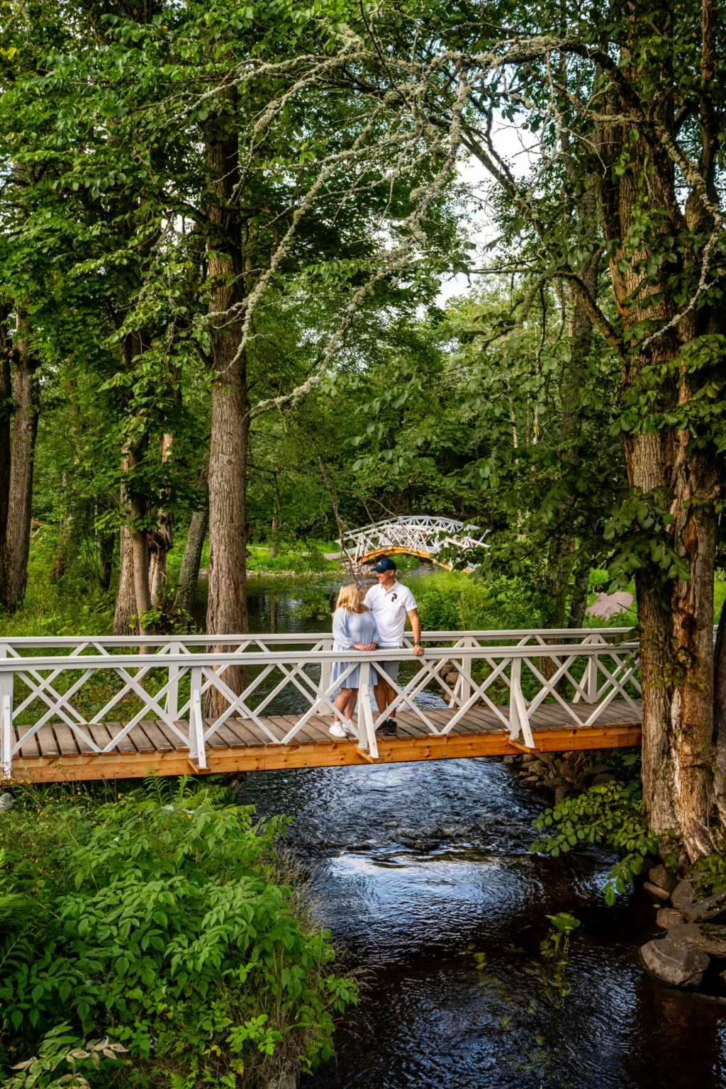 en kvinna och en man håller om varandra på en bro i engelska parken i grängshammar