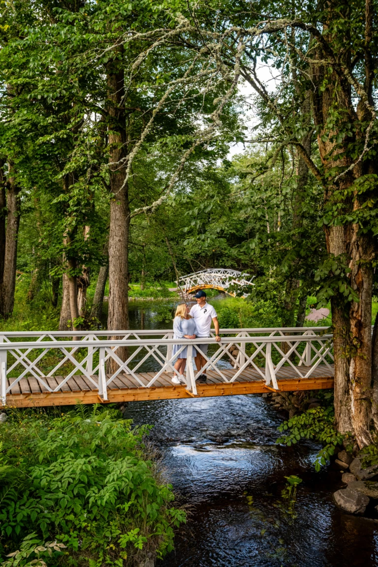 en kvinna och en man håller om varandra på en bro i engelska parken i grängshammar