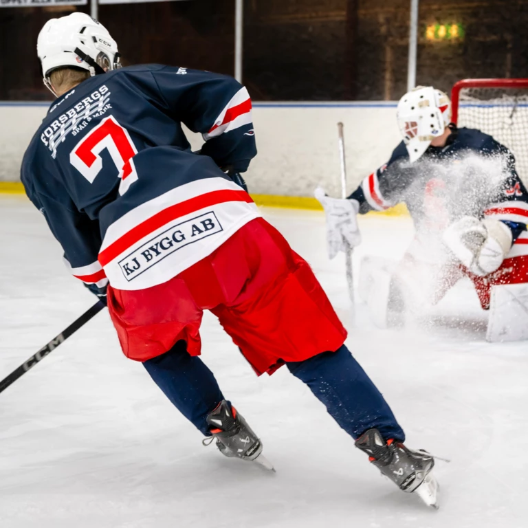Hockeyspelare försöker göra mål på målvakt