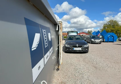 Vy över området där mobila återvinningscentralen fanns på plats i Stora Skedvi, med containrar och bilar.