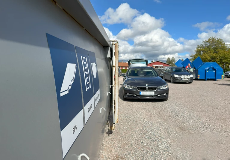 Vy över området där mobila återvinningscentralen fanns på plats i Stora Skedvi, med containrar och bilar.