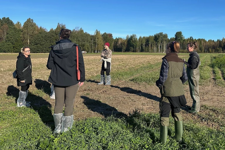 Tjänstepersoner och politiker samlas kring Finley som berättar om småskaligt jordbruk